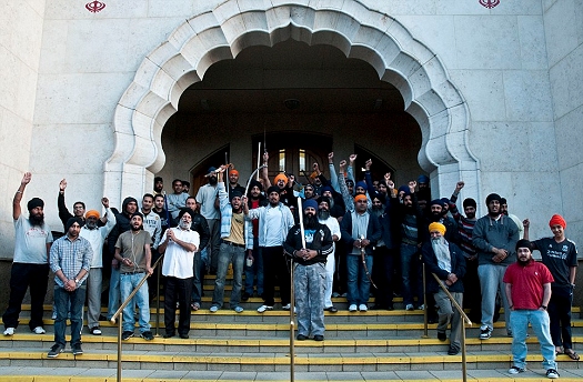 A group of Sikhs standing guard outside Southall Gurdwara Sahib